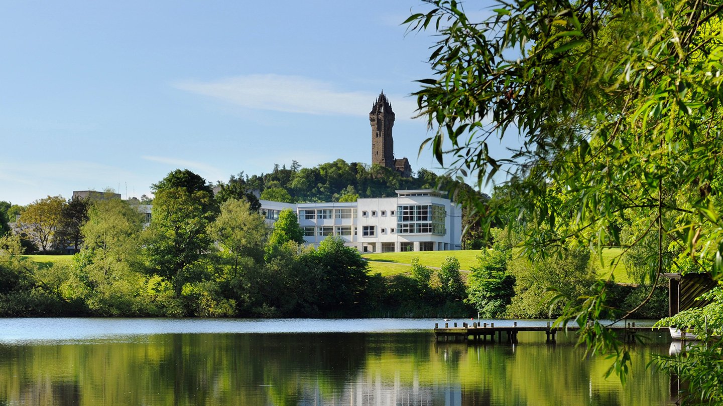  Aerial view of Stirling University's picturesque campus in the United Kingdom surrounded by greenery.